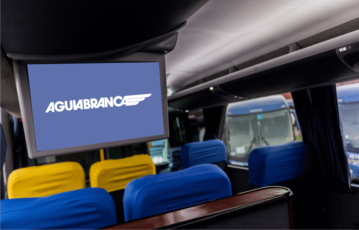 Imagem ilustrativa de uma smarttv, dos assentos e do corredor de um dos ônibus da Águia Branca